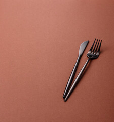 Knife and fork, cutlery on a brown dining table