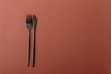 Knife and fork, cutlery on a brown dining table