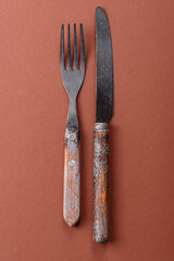 Knife and fork, cutlery on a brown dining table