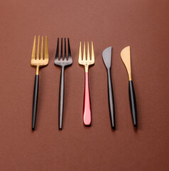 Knife and fork, cutlery on a brown dining table