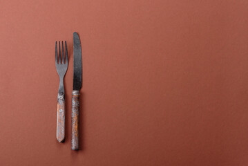 Knife and fork, cutlery on a brown dining table