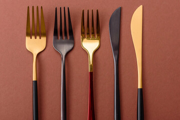 Knife and fork, cutlery on a brown dining table