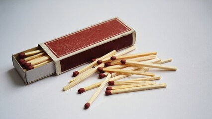 A box of matches with a few of them left out of the box. The box is red and white