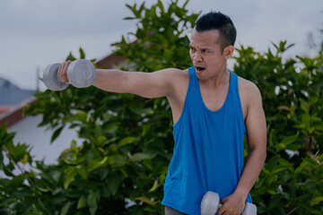 Shoulder workout and training. Asian man doing shoulder exercises using dumbbells.