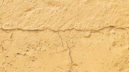 Cracked yellow plaster wall texture