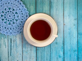 Cup of tea and crocheted doily mandala photo	
