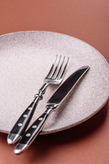 Empty ceramic plate on a monochrome brown background