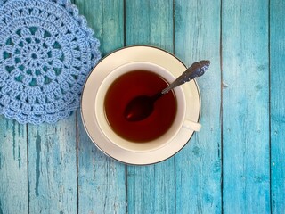 Cup of tea and crocheted doily mandala photo