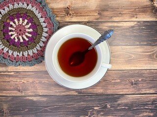 Cup of tea and crocheted doily mandala photo	
