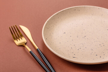 Empty ceramic plate on a monochrome brown background