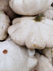 Close-up of stacked white pattypan squashes with subtle textures and natural imperfections on their surfaces
