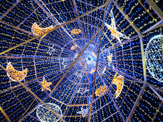 Stunning low-angle view of a dazzling light installation featuring stars and moons.  Perfect for holiday, celebration, or whimsical designs.