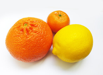Vibrant citrus fruits a juicy orange, a mandarin, and a zesty lemon, arranged on a clean white background. This image conveys freshness, health, and the concept of variety.