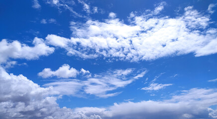 Obraz premium Vibrant blue sky dotted with fluffy white clouds, evoking feelings of freedom, peace, and endless possibilities. Ideal for backgrounds, designs symbolizing optimism, or nature themes.