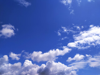 Vibrant blue sky punctuated by fluffy clouds. A serene, uplifting image suggesting freedom, openness, and possibility. Ideal for backgrounds, presentations, or web design.