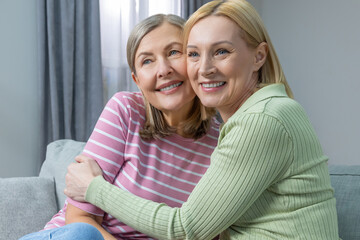 Smiling women hugging each other, smiling and feeling close