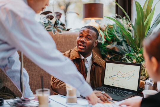 A diverse group of colleagues discusses data and business strategies while bonding in a dynamic cafe atmosphere, fostering teamwork, innovation, and professional growth.