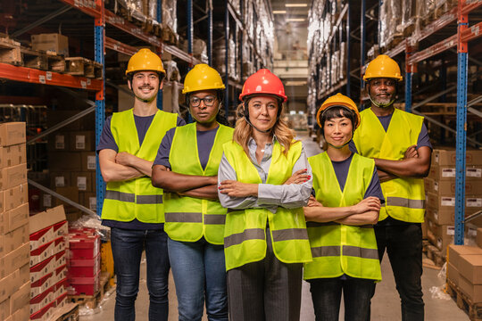 Warehouse workers standing with arms crossed in logistics center