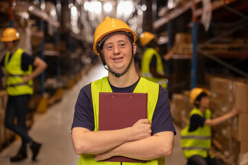 Portrait of warehouse worker with down syndrome holding clipboard, smiling at logistics center