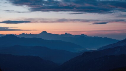 Obraz premium Sunlight setting on rugged mountain landscape at dusk.