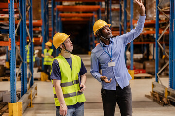 Managers discussing logistics inside warehouse storage room