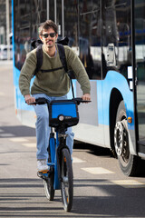 Man riding a bike share bicycle in the city, enjoying sustainable transportation