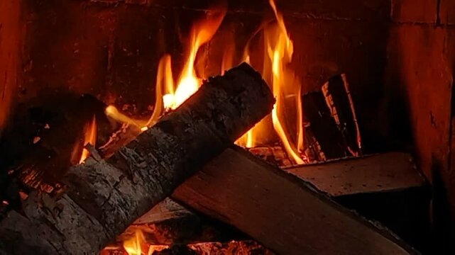Horizontal video of wood burning in a small fireplace