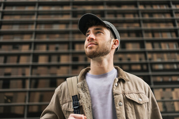 Portrait of a young student wearing cap looking to the side with inspiration in the city 