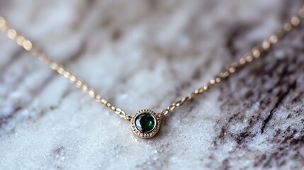 Fototapeta premium Delicate gold necklace with emerald pendant on marble