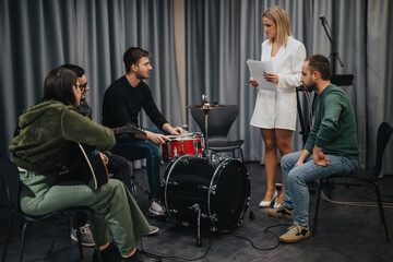A group of individuals practicing together in a studio, equipped with instruments and notes, collaborating for a music project or upcoming performance, reflecting creativity and teamwork. © qunica.com