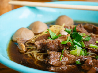 Braised beef noodle soup set on wooden table.