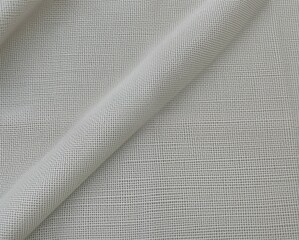 A close-up view of a textured fabric showcasing a fine mesh pattern in light gray tones.