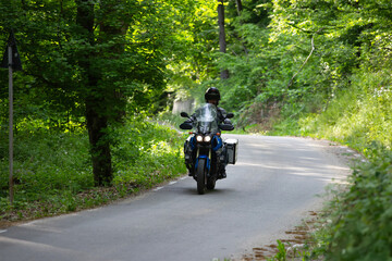 Motorcycle rider on the road in the forest