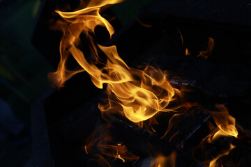 Fototapeta premium Close-up of Vibrant Orange Flames with Dark Background - Dynamic Fire and Heat Concept