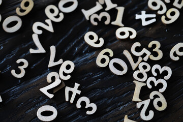 Scattered Wooden Numbers on Dark Wooden Surface: Vintage Numerals Background
