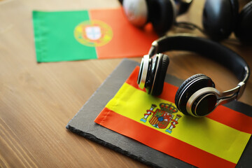 Headphones on Spanish Flag with Portuguese Flag in Background - Symbolizing Music and Culture Connection