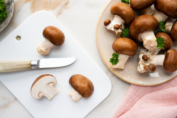 A plate filled with fresh raw brown champignon mushrooms, ready for cooking.