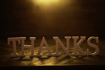 Lit Wooden Thanks Sign on Rustic Wooden Table with Soft Warm Lighting