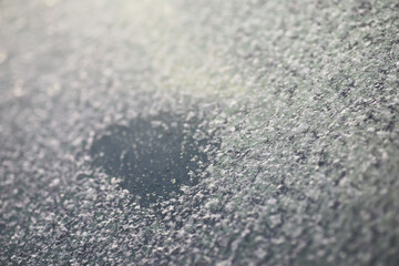 Obraz premium Frosty Car Window with Snowflakes Creating a Heart Shape on a Winter Morning
