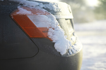 Snow-Covered Car Tail Light in Winter Morning Sunlight