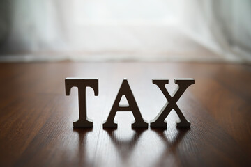 Wooden Floor with TAX Letters in Focus Symbolizing Financial Responsibility and Taxation Concepts