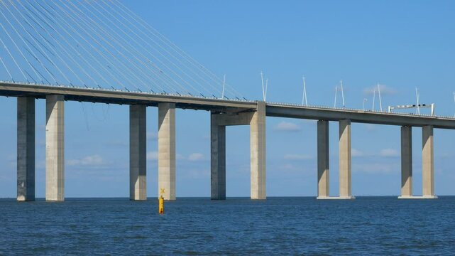 Vasco da Gama Bridge floats above the river, forming an abstract architectural background. Clean horizontal lines, deep blue water, and minimalist design blend with sky and colorful buoys.