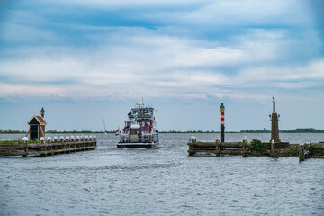 An excursion boat leaves the port of Volendam under a heavily cloudy sky
