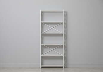 Empty shelving unit near light grey wall