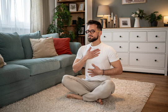Man practicing deep breathing exercise at home for stress relief