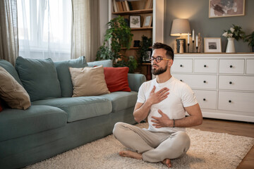 Young man practicing deep breathing exercise at home