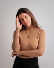 Thinking brown haired woman standing against isolated bacgkround