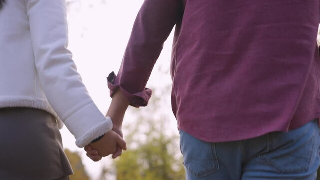 a close up shot of a couple holding hands while exploring a park in port Coquitlam.