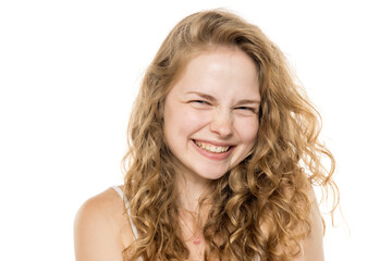Happy young woman with long curly blonde hair and freckles, no makeup. Close-up portrait on white background