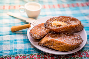 Traditional Spanish torrijas, dessert often enjoyed during Lent and Holy Week or Semana Santa, and Easter, similar to french toast, with cup or coffee or cappuccino, ready for breakfast